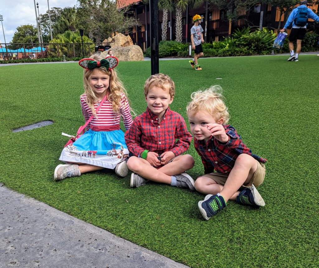 Blair's kids on the fake lawn behind the Polynesian Resort
